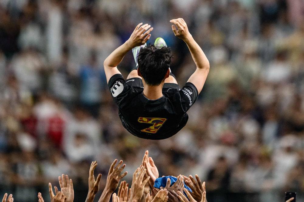 Teammates lift Tottenham Hotspur's captain Son Heung-min up in the air during celebrations to bid him farewell at the end of a friendly football match between Tottenham Hotspur and Newcastle United in Seoul on August 3, 2025. The 33-year-old South Korean striker said on August 2, that he will leave the club this summer after a decade in north London. (Photo by Anthony WALLACE / AFP)