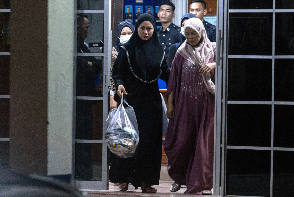 Eda Ezrin (left) with her mother Zahara Mamat, 47, after giving a statement to the police for over three hours at the Rantau Panjang Police Station yesterday. - Bernama photo