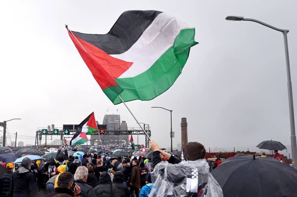 Demonstrators march across the Sydney Harbour Bridge during a pro-Palestinian rally against Israel's actions and the ongoing food shortages in the Gaza Strip, in Sydney on August 3, 2025. (Photo by DAVID GRAY / AFP)