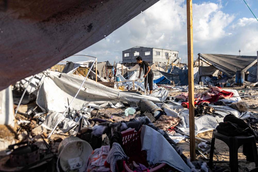 A boy walks with crutches as he inspects the scene in the aftermath of overnight Israeli bombardment on a camp sheltering displaced people in the Mawasi area of Khan Yunis in the southern Gaza Strip on August 5, 2025. (Photo by AFP)