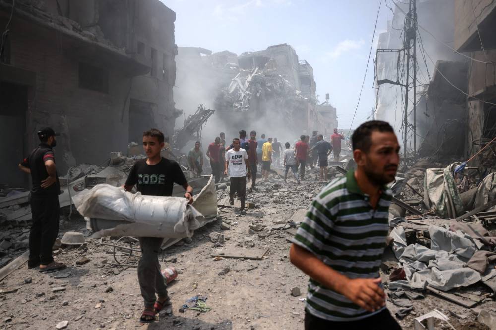 Palestinians check the devastation following an Israeli strike that hit Gaza City's southern al-Zeitoun neighbourhood on Aug 8. Photo by Bashar Taleb/AFP