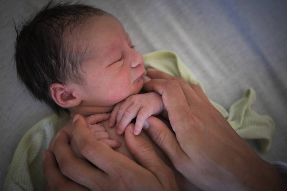 A mother looks after her newborn baby in hospital in Nantes, western France, on July 8, 2018. (Photo by LOIC VENANCE/AFP)