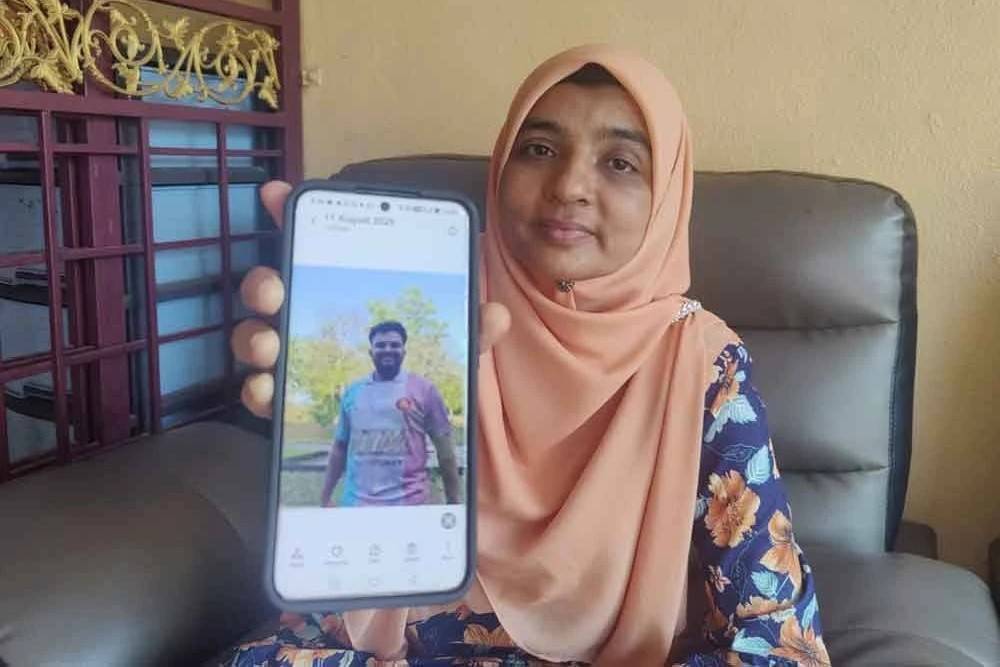 Ummu Haiman shows a picture of her late son when met by Sinar at her home on Aug 11.
