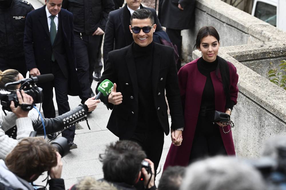 Former Real Madrid player Cristiano Ronaldo gives a thumbs-up as he arrives with his Spanish girlfriend Georgina Rodriguez. (Photo by PIERRE-PHILIPPE MARCOU / AFP)
