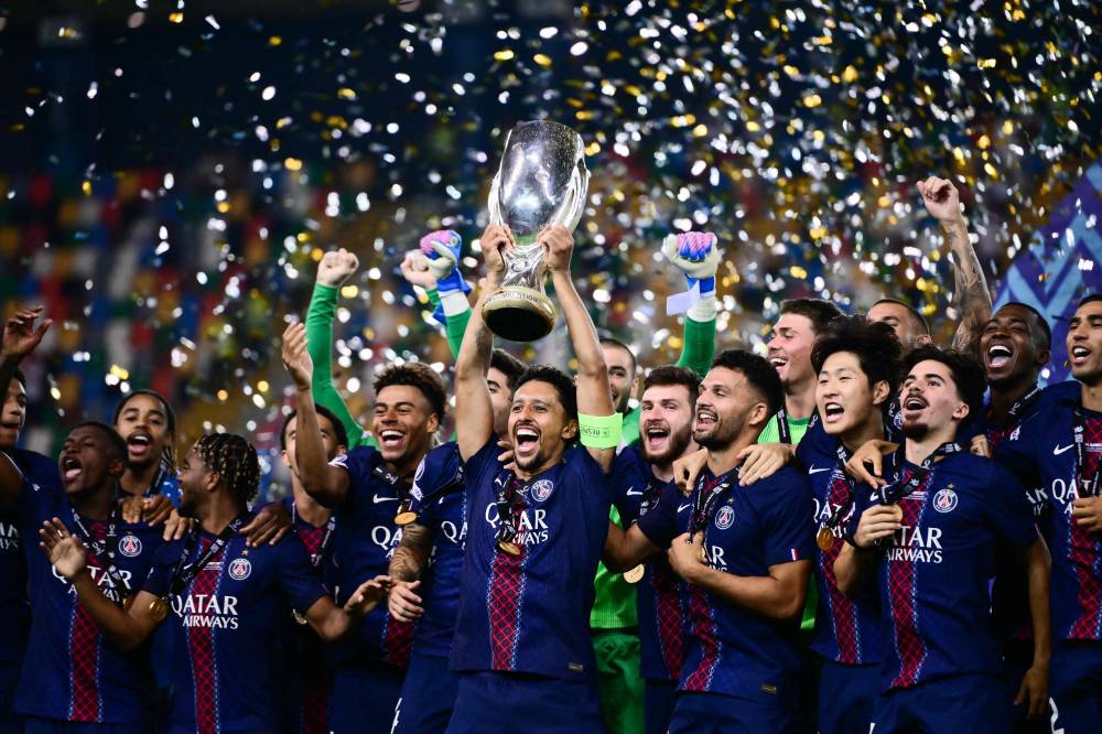 Paris Saint-Germain's Brazilian defender Marquinhos lifts the trophy as Paris Saint-Germain celebrate winning the 2025 UEFA Super Cup final football match between Paris Saint-Germain (FRA) and Tottenham Hotspur FC (ENG) at the Friuli stadium, in Udine, on August 13, 2025. (Photo by Marco BERTORELLO / AFP)