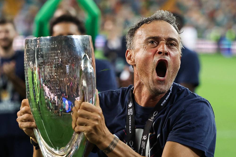 Paris Saint-Germain's Spanish headcoach Luis Enrique celebrates with the trophy after winning the 2025 UEFA Super Cup final football match between Paris Saint-Germain (FRA) and Tottenham Hotspur FC (ENG) at the Friuli stadium, in Udine, on August 13, 2025. (Photo by FRANCK FIFE / AFP)