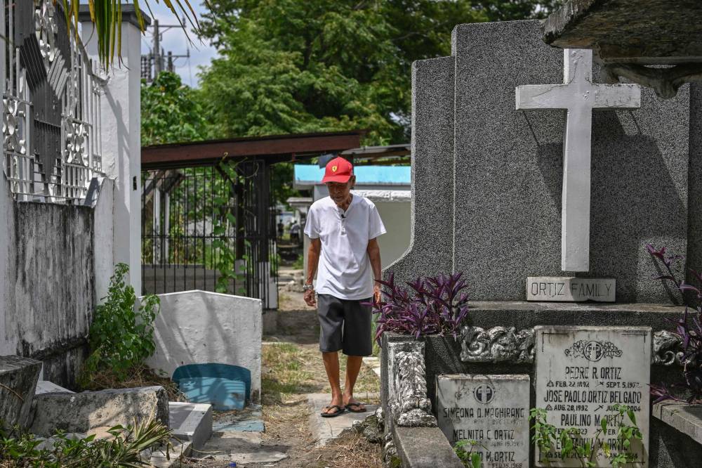 In this photo taken on August 1, 2025, Jose Villafuerte walks after visiting his mother's grave near his home in San Pablo, Laguna. After a lifetime of searching, Jose Villafuerte this month finally found the Japanese father he lost during the dark years of World War II in the occupied Philippines. The 82-year-old, a former gravedigger, was still in the womb of his Filipina mother, Benita Abril, when her partner, imperial army officer Ginjiro Takei, returned to Japan during its brutal occupation of the archipelago from 1942-45. (Photo by Jam STA ROSA / AFP)
