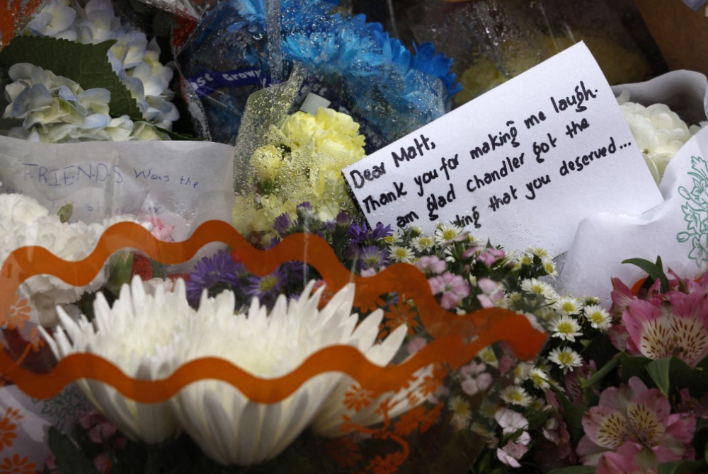 Flowers and a note are placed at the memorial as fans pay tribute to the late actor Matthew Perry outside "Friends" building on October 30, 2023 in New York City. (Photo by John Lamparski / GETTY IMAGES NORTH AMERICA / Getty Images via AFP)