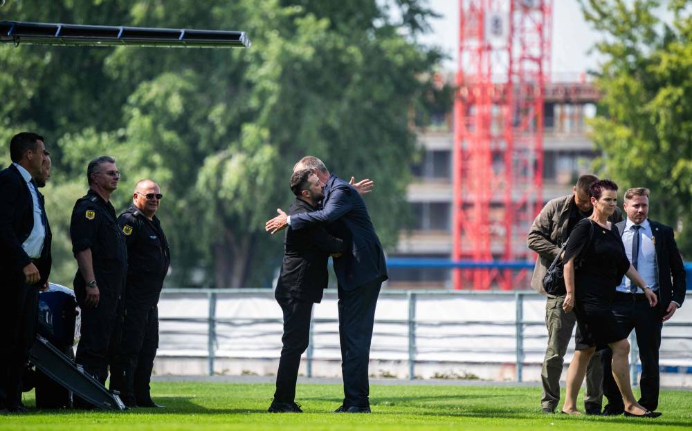 German Chancellor Friedrich Merz (Centre, R) welcomes Ukrainian President Volodymyr Zelensky (Centre, L) upon his arrival in the garden of the chancellery in Berlin to join a video conference of European leaders with the US President on the Ukraine war ahead of the summit between the US and Russian leaders, on August 13, 2025. European leaders will hold online talks with US President Donald Trump, hoping to convince him to respect Ukraine's interests when he discusses the war with Putin in Alaska on Friday. (Photo by John MACDOUGALL / POOL / AFP)