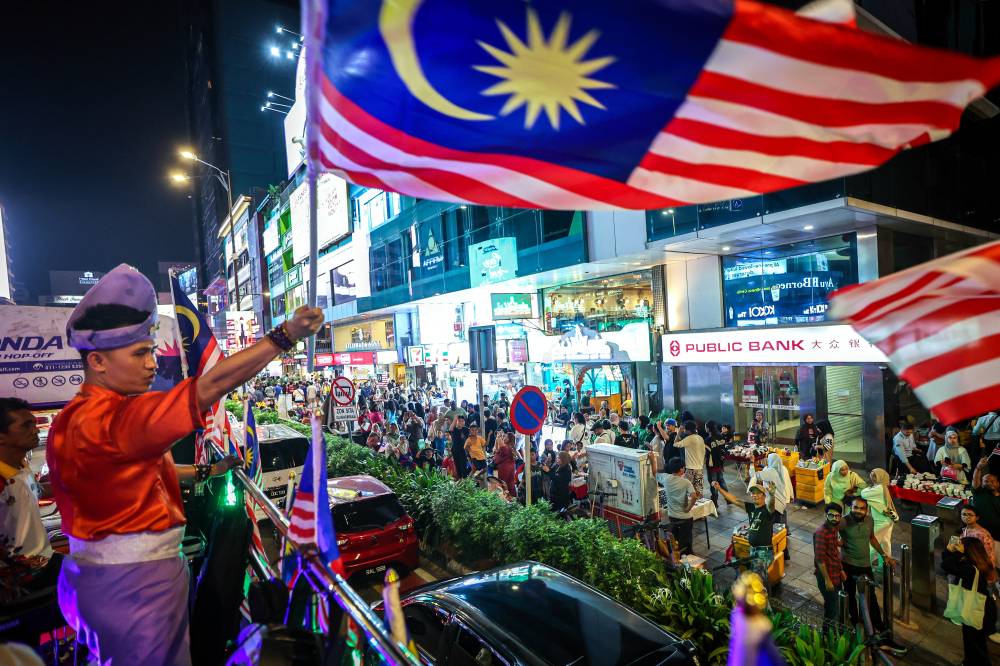 For three hours touring around the capital city, the Hop-On Hop-Off bus (KL HOHO) adorned with Jalur Gemilang proved to be an eye-catching attraction for everyone who saw it. Photo by Bernama