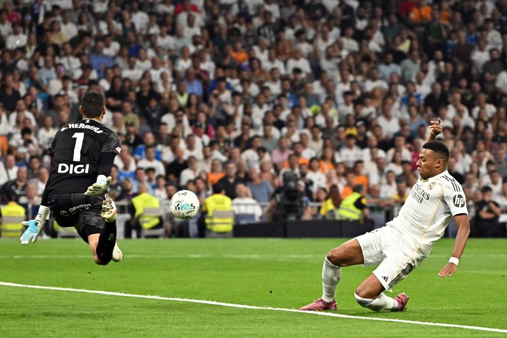 Real Madrid's French forward #10 Kylian Mbappe (R) misses a goal opportunity during the Spanish league football match between Real Madrid CF and CA Osasuna at Santiago Bernabeu Stadium in Madrid on August 19, 2025. (Photo by Javier SORIANO / AFP)