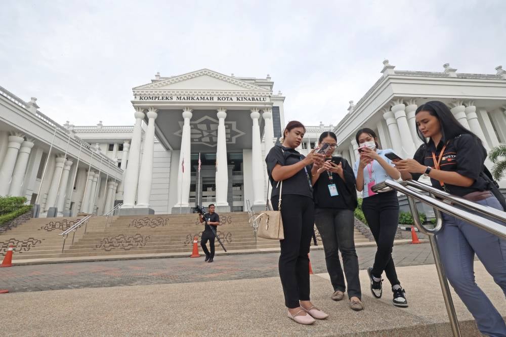 Journalists gather outside the Kota Kinabalu Courts Complex to cover the case of five teenage girls scheduled to be charged at the Juvenile Court today in connection with the bullying of Zara Qairina Mahathir. - Photo by Bernama