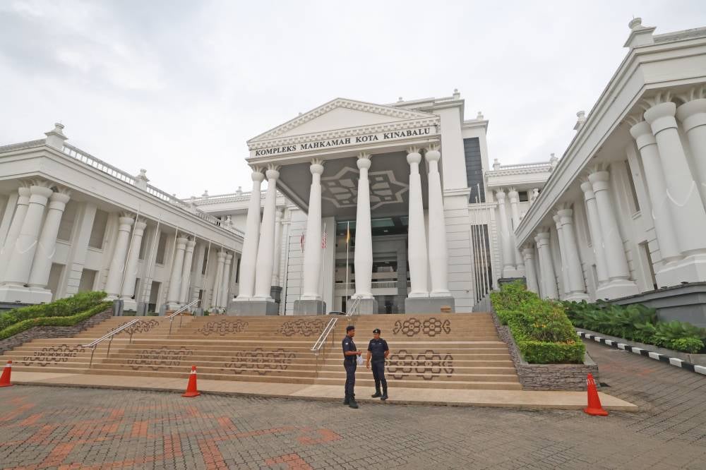 Security personnel stand guard outside the Kota Kinabalu Courts Complex as five teenage girls are scheduled to be charged at the Juvenile Court today in connection with the bullying of student Zara Qairina Mahathir. - Photo by Bernama
