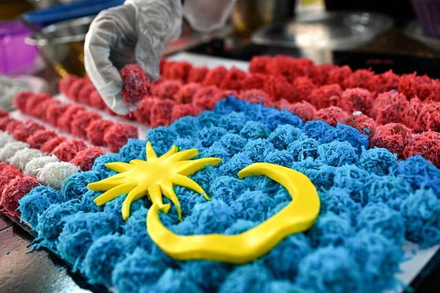  A total of 10,000 pieces of onde-onde were used to create a 41-metre replica of the Jalur Gemilang, one of the unique highlights of the 68th National Day celebration at the Kesedar Chalil Land Development Plan. - Photo by Bernama