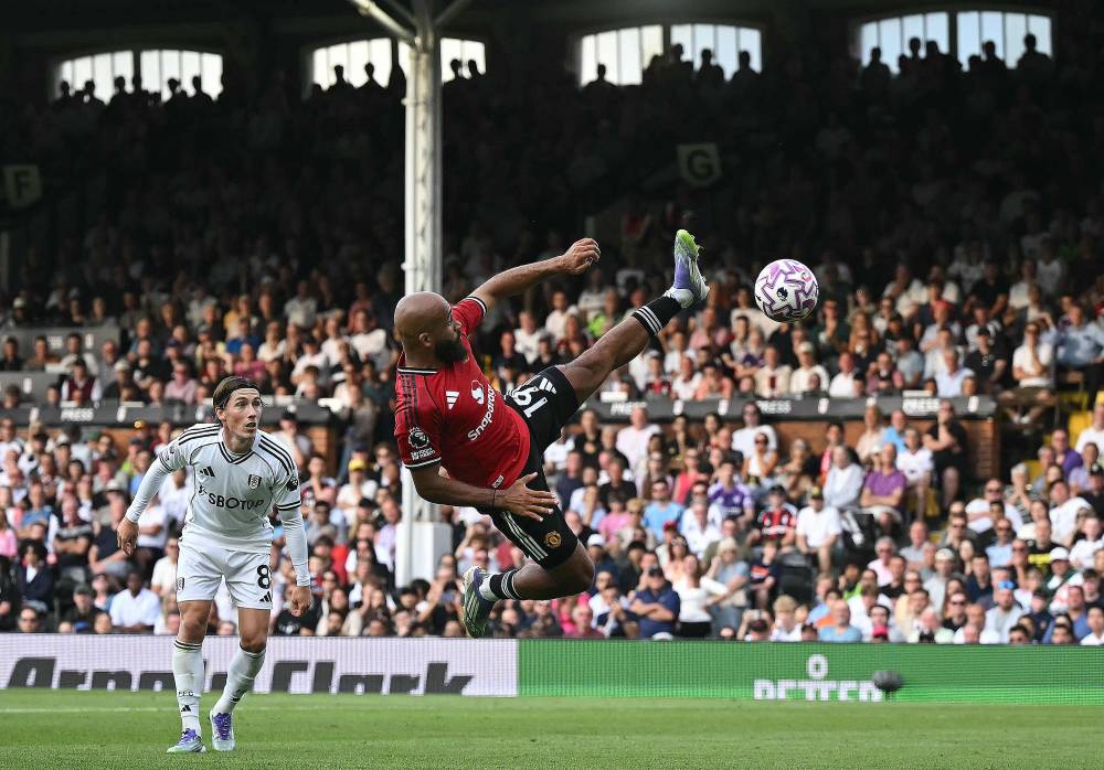 Manchester United's Cameroonian midfielder #19 Bryan Mbeumo attempts a flying kick but fails to connect witht he ball during the English Premier League football match between Fulham and Manchester United at Craven Cottage in London on August 24, 2025. (Photo by JUSTIN TALLIS / AFP) 