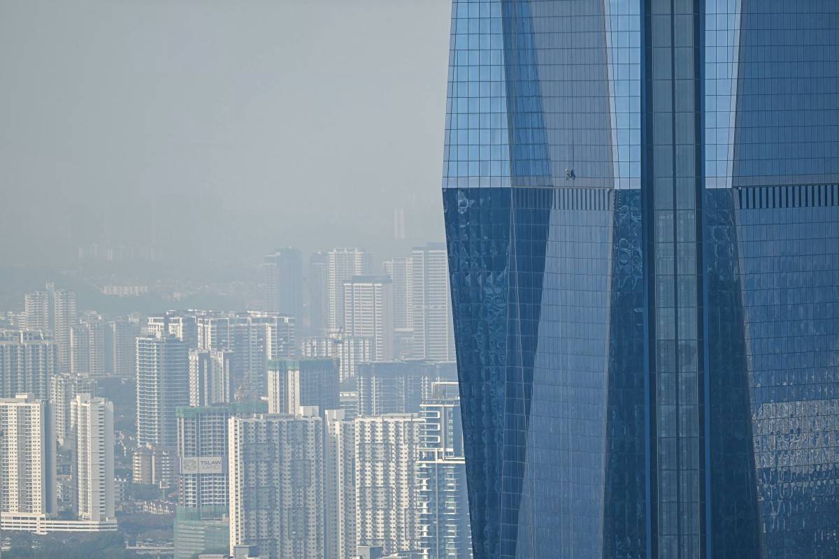 A worker cleans the windows of Warisan Merdeka Tower (KL118) the second tallest building in the world, in Kuala Lumpur on August 19, 2025. (Photo by Mohd RASFAN / AFP)