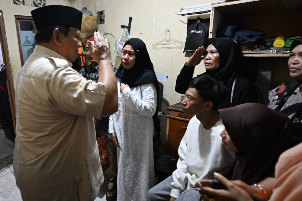 Indonesian President Prabowo Subianto (L) visiting the house of Affan Kurniawan, a 21-year-old motorcycle taxi driver who was killed after being run over by an armored Brimob (Mobile Brigade Corps) vehicle during a protest, to offer his condolences to the family in Jakarta. Photo by Handout/Indonesia's Presidential Palace/AFP