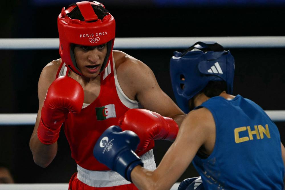 Algeria's Imane Khelif and China's Yang Liu (Blue) compete in the women's 66kg final boxing match during the Paris 2024 Olympic Games at the Roland-Garros Stadium, in Paris on Aug 9, 2024. - (Photo by MAURO PIMENTEL / AFP)