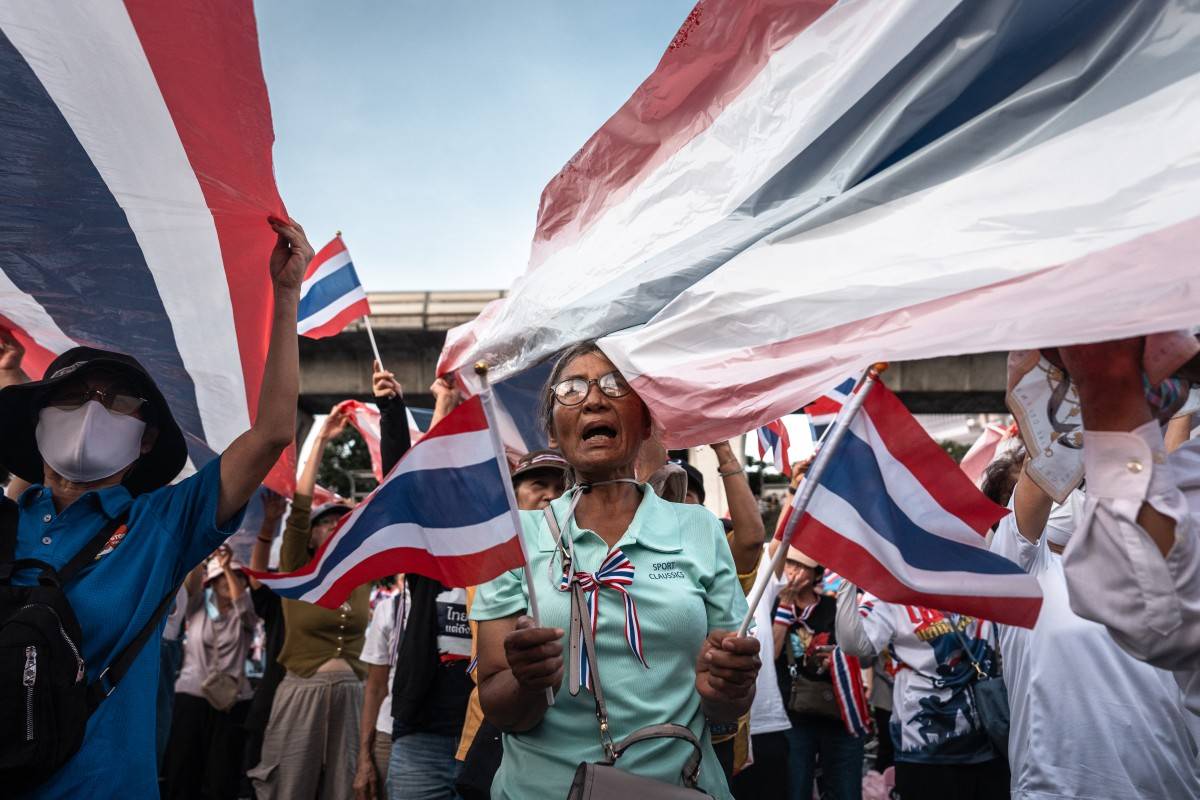 Anti-government protesters hold Thai national flags during a rally to condemn war with Cambodia and demand the resignation of Thailand’s suspended prime minister Paetongtarn Shinawatra, at Victory Monument in Bangkok on August 2, 2025. (Photo by Chanakarn Laosarakham / AFP)