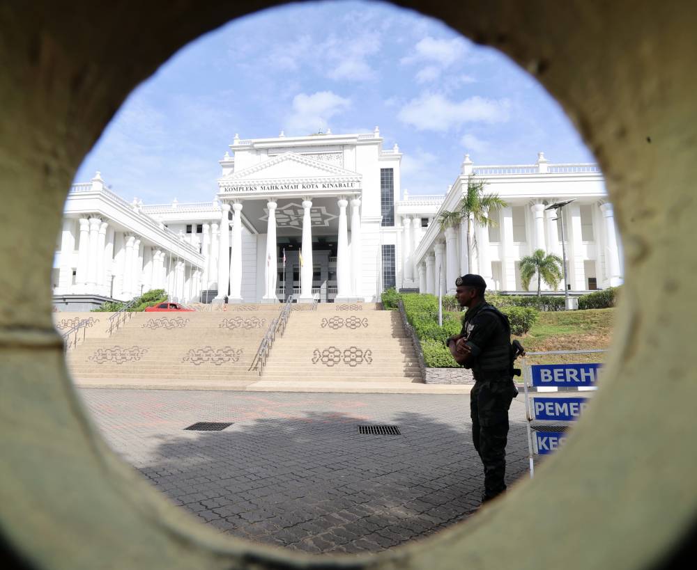 Police officers stood guard outside the Kota Kinabalu Court Complex during the inquest proceedings into the death of Zara Qairina Mahathir on Sept 3. - Photo by Bernama