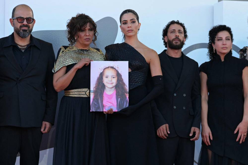 From left: (From L) Israelian actor Amer Hlehel, Tunisian director Kaouther Ben Hania, actress Saja Kilani, actor Motaz Malhees, actress Clara Khoury pose with a portrait of late Palestinian girl Hind Rajab, during the red carpet for the movie 