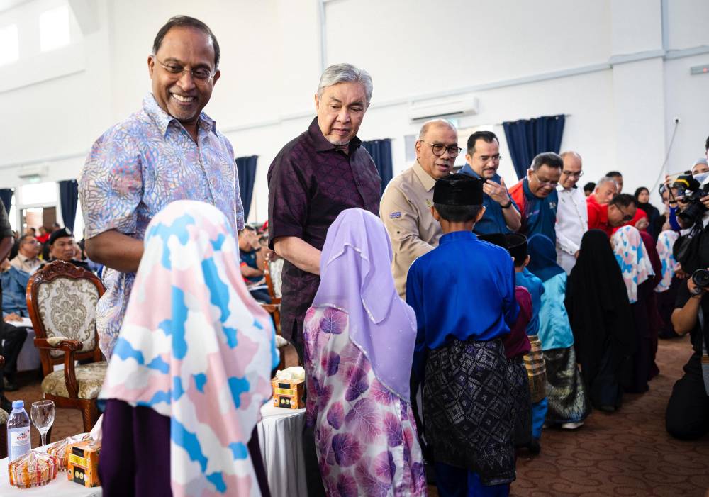 Deputy Prime Minister and Minister of Rural and Regional Development Datuk Seri Dr Ahmad Zahid Hamidi, greeting KEMAS students during the Desa Motivation@KEMAS KKDW and Bakti MADANI@KPT Programme at Tuminah Hamidi Mosque on Sept 7, 2025. Also present was Higher Education Minister, Datuk Seri Dr Zambry Abd Kadir (left). (BERNAMA PHOTO)