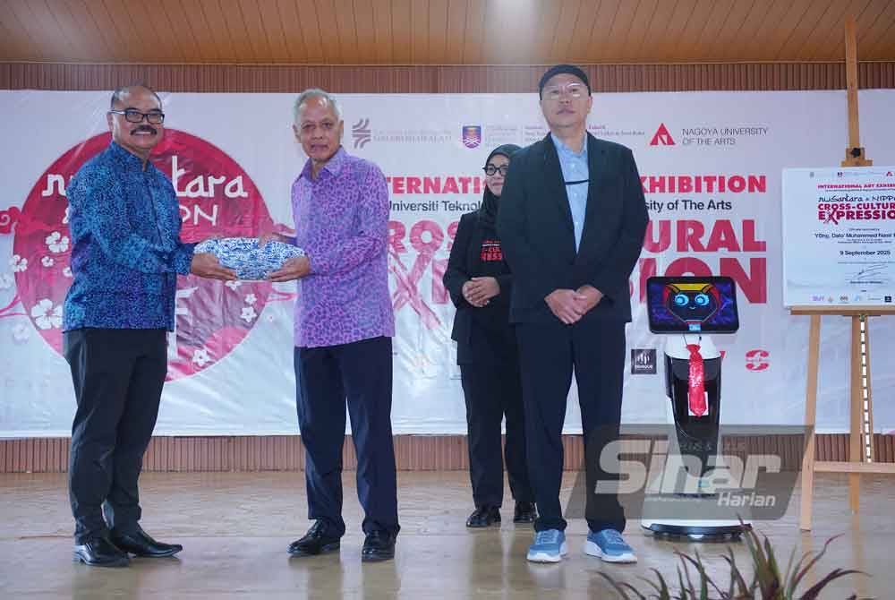 Muhammad Kipli (left) presents a souvenir to Muhammad Nasir (centre) during the opening ceremony of the international art exhibition 'Nusantara & Nippon: Cross-Culture Expression'.