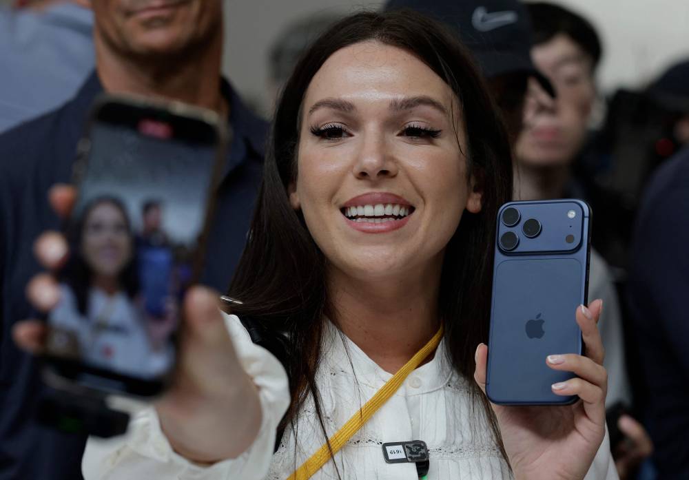 An attendee makes a video of herself holding a new Apple iPhone 17 Pro during an Apple special event at Apple headquarters on Sept 9 in Cupertino, California. Apple unveiled a new generation of iPhones, updated Apple Watches, and AirPods during a special event at its headquarters. (Photo by JUSTIN SULLIVAN / GETTY IMAGES NORTH AMERICA / Getty Images via AFP)