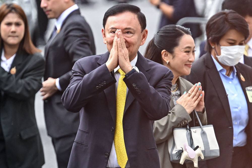 Thailand's former Prime Minister Thaksin Shinawatra (centre) is escorted into a police van outside the Supreme Court in Bangkok after he was sentenced to a year in prison. AFP FILE PIX