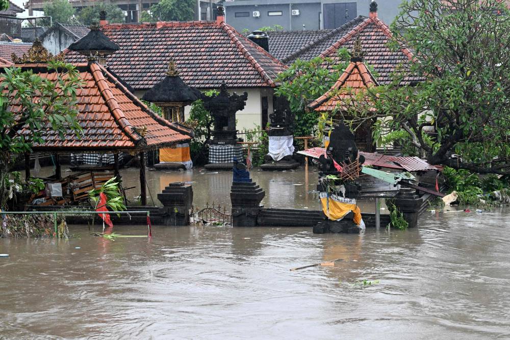 A Hindu temple is inundated by floodwaters following heavy rain in Denpasar, Indonesia's Bali island, on September 10, 2025. (Photo by SONNY TUMBELAKA / AFP)