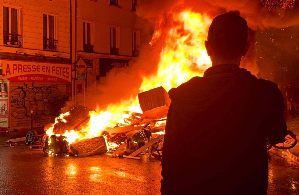 A man watches a fire set by protesters, blocking a street near the Place des Fetes, during a demonstration as part of the "Bloquons tout" ("Let's block everything") protest movement, in Paris, on Sept 10. The broad anti-government campaign, dubbed "Bloquons tout" ("Let's block everything"), calls for a a shutdown of France on Sept 10 with a string of protest actions and civil disobedience around the country, while the handover of power between the new Prime Minister and his predecessor, who suffered a crushing loss in a confidence vote on September 8, is scheduled for the same day at noon. (Photo by Aurore MESENGE / AFP)
