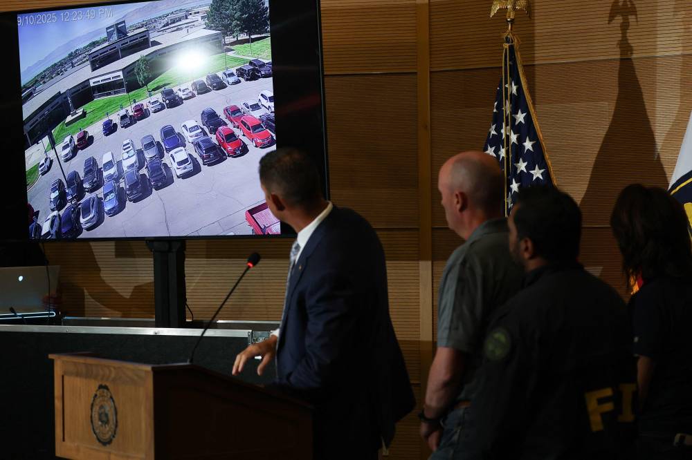 (L-R) Utah Department of Public Safety Beau Mason, Utah Governor Spencer Cox and FBI Director Kash Patel watch a video during a press conference outside the Doterra Auditorium at Utah Valley University a day after youth activist and influencer Charlie Kirk was shot during a public event in Orem, Utah, on Sept 11. (Photo by Patrick T. Fallon / AFP)