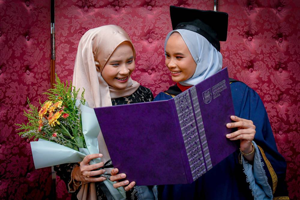 Yusren Yusoff, 24, a graduate with a Bachelor's degree in Mass Communication (Journalism) with her twin Yusrah when met after the 102nd Universiti Teknologi Mara (UiTM) Convocation Ceremony (May 2025 Session) at the Dewan Agung Tuanku Canselor (DATC), UiTM Shah Alam, yesterday. - Photo by Bernama