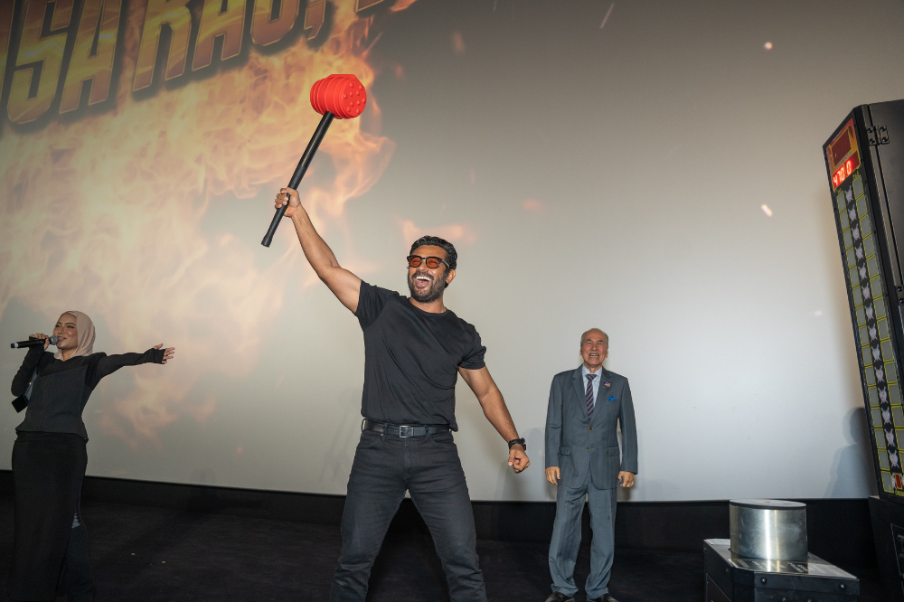 Datuk Remy showcasing his strength on the King of Hammer machine, symbolising the bold energy of the #KuasaKauKaw campaign.