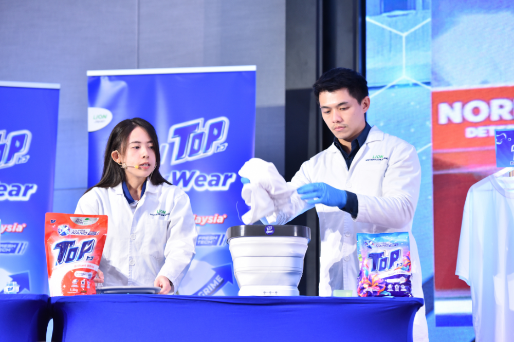 R&D team from Southern Lion Malaysia demonstrating the effectiveness of the improved TOP detergent with Ultra Nano Fresh Tech in eliminating invisible body grime compared to the normal detergent to the audiences. -Photo: TOP