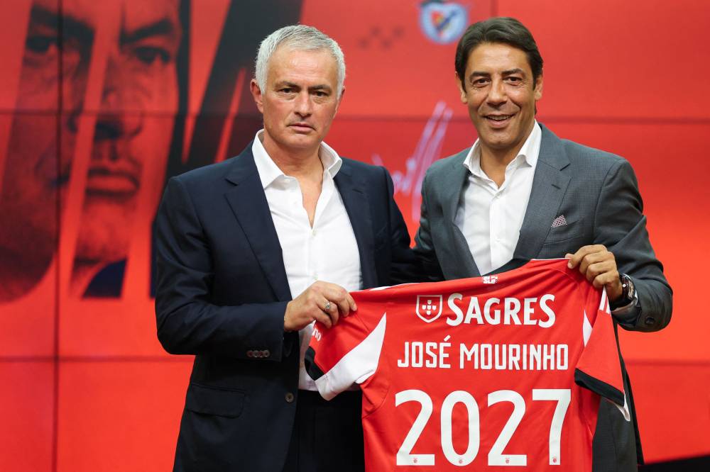 Portuguese coach Jose Mourinho (L) holds up a Benfica jersey with his name together with Benfica president Rui Costa during his official presentation as new Benfica coach at the Benfica Campus training center in Seixal, on the outskirts of Lisbon, on September 18, 2025. Benfica sacked Portuguese coach Bruno Lage following their defeat to Qarabag on September 16, 2025 evening in the Champions League, and contacted Jose Mourinho the next day to hire him. (Photo by PATRICIA DE MELO MOREIRA / AFP)