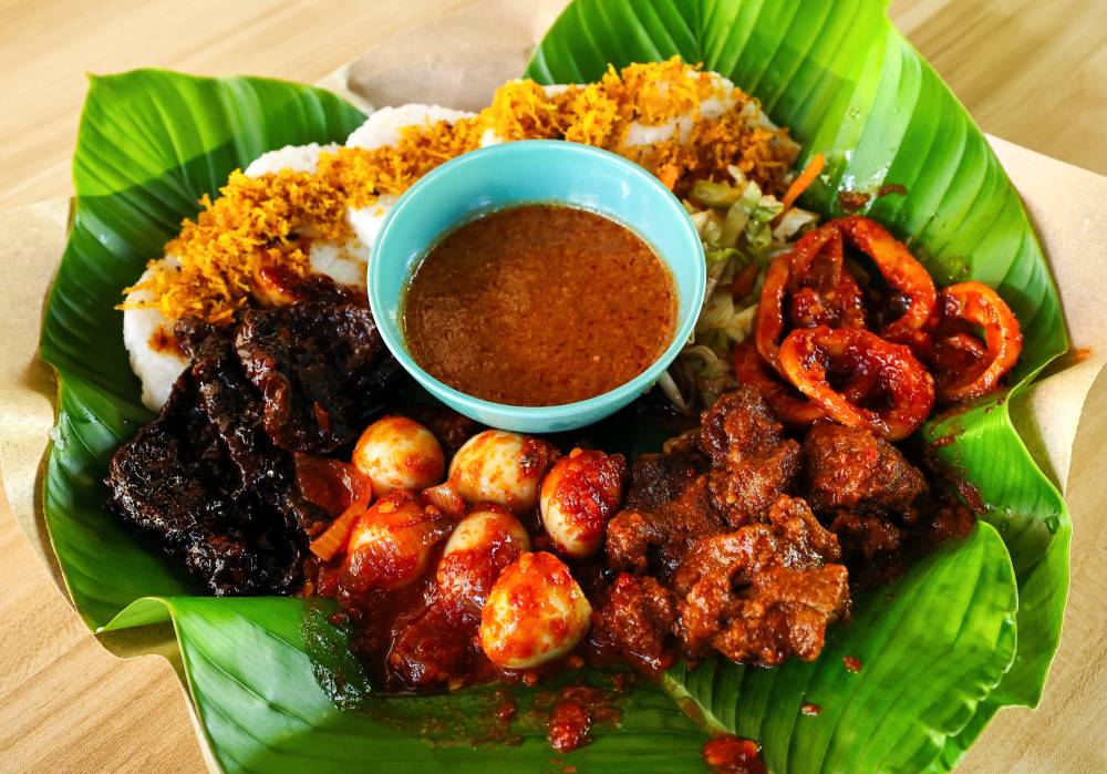 Lontong darat is served dry, with a selection of side dishes such as chicken or beef rending and serunding (meat floss). - Bernama photo