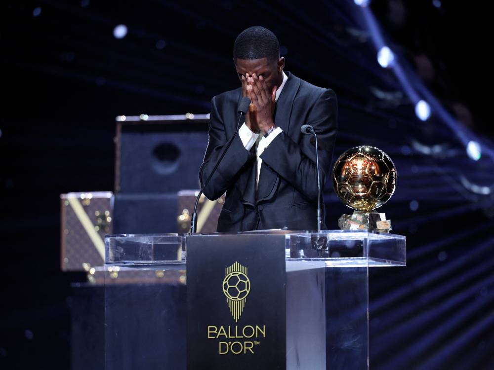 Paris Saint-Germain's French forward Ousmane Dembele reacts after receiving the Ballon d'Or award during the 2025 Ballon d'Or France Football award ceremony at the Theatre du Chatelet in Paris on September 22, 2025. (Photo by Franck FIFE / AFP)