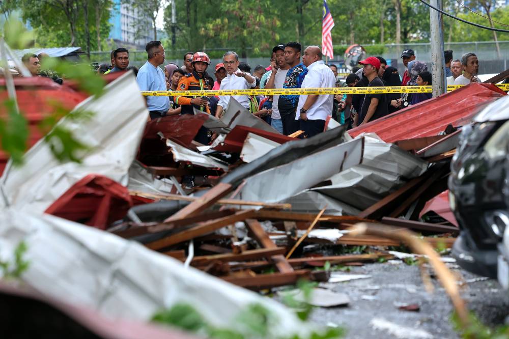 Communications Minister and Lembah Pantai Member of Parliament Datuk Fahmi Fadzil inspecting damaged homes and vehicles following a storm at the Seri Cempaka PPR this evening. - Bernama photo