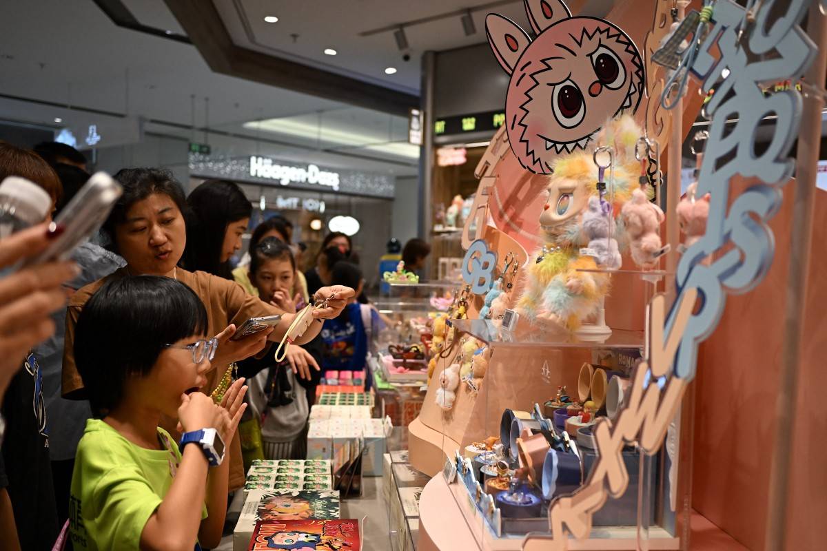 People check out newly-launched mini Labubu toys at a Pop Mart shop in Beijing on Aug 29, 2025. (Photo by Jade Gao / AFP)