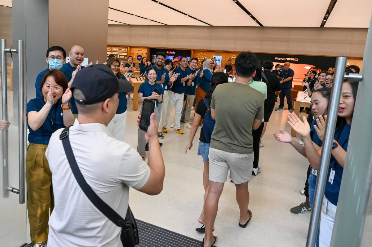 People enter the Apple shop outlet for the newly launch of iPhone 17 series. Photo by Roslan Rahman/AFP