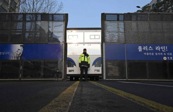 A police officer stands guard in front of a police barricade near the Constitutional Court in Seoul on April 4, 2025. (Photo by Jung Yeon-je / AFP)