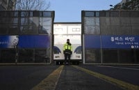 A police officer stands guard in front of a police barricade near the Constitutional Court in Seoul on April 4, 2025. (Photo by Jung Yeon-je / AFP)