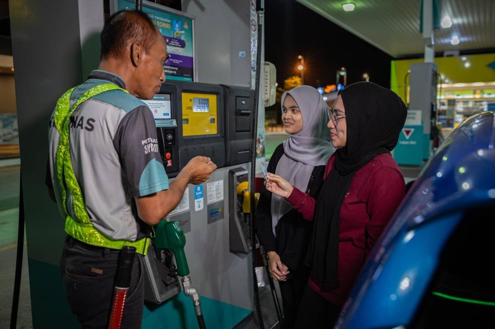 BUDI95 recipient, Rania Ardini Mohd Asri, refuels with RON95 petrol at a cheaper price after benefiting from the BUDI95 initiative during a visit to a petrol station along Jalan Sultan Azlan Shah early this morning. - Photo by Bernama