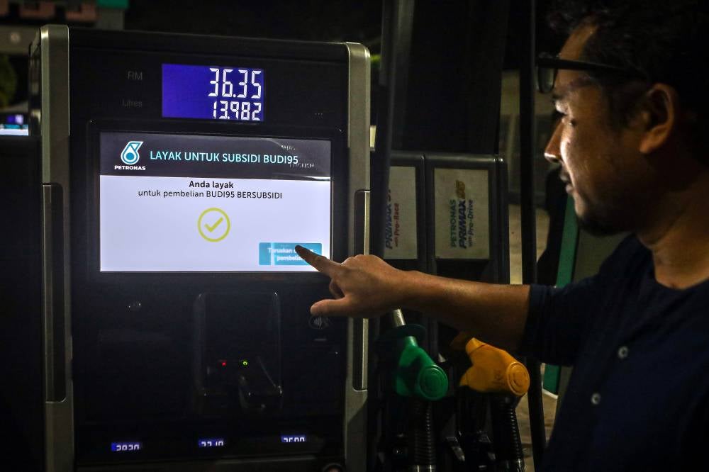 UNIMAP lecturer Shahrir Rizal Kasjoo refuels with RON95 petrol at a cheaper price after benefiting from the BUDI95 initiative during a visit to a petrol station in Jejawi early this morning. - Photo by Bernama