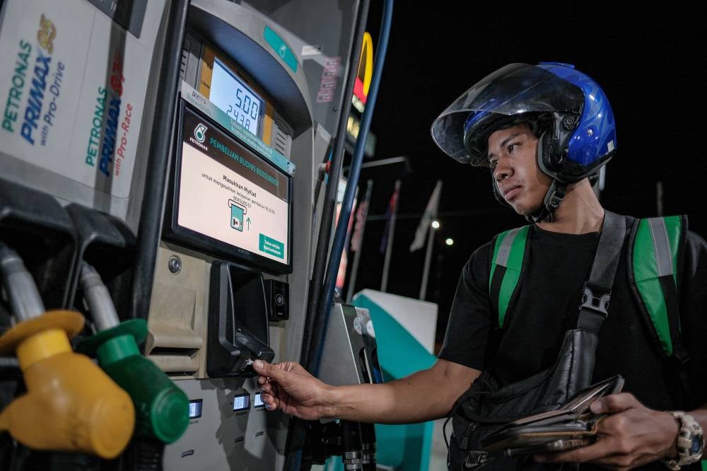 Gig worker Muhammad Iqbal Mohd Nizar refuels with RON95 petrol at a cheaper price after benefiting from the BUDI95 initiative during a visit to a petrol station at KM11 Jalan Skudai early this morning. - Photo by Bernama