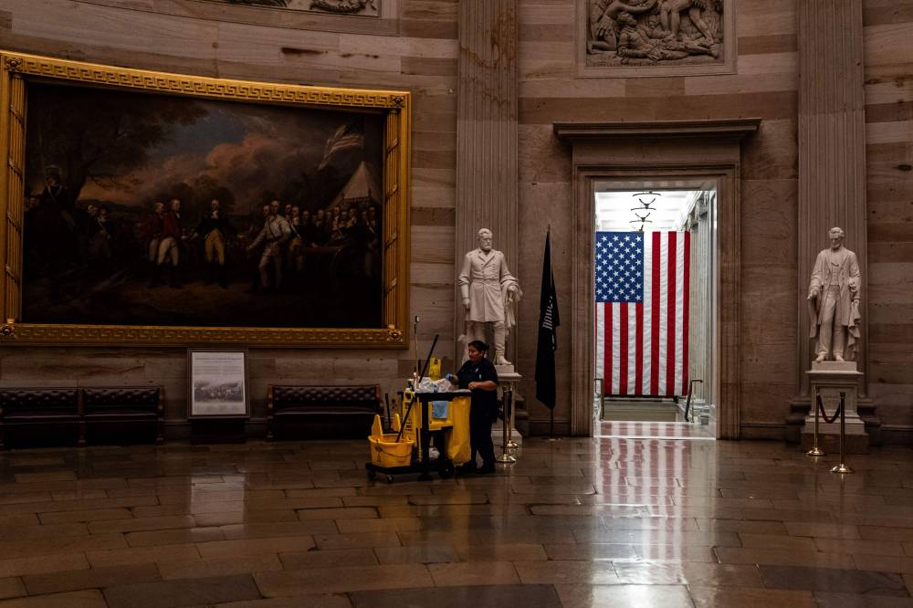 A maintenance worker pushes a cleaning cart through the rotunda of the US Capitol in Washington, DC. Photo by Kent Nishimura/AFP