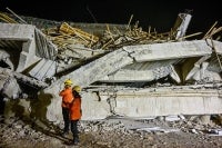 Rescue personnel inspect the site after a building collapsed at an Islamic boarding school in Sidoarjo, East Java province, injuring a number of students and trapping several others under the rubble. Photo by Juni Kriswanto/AFP