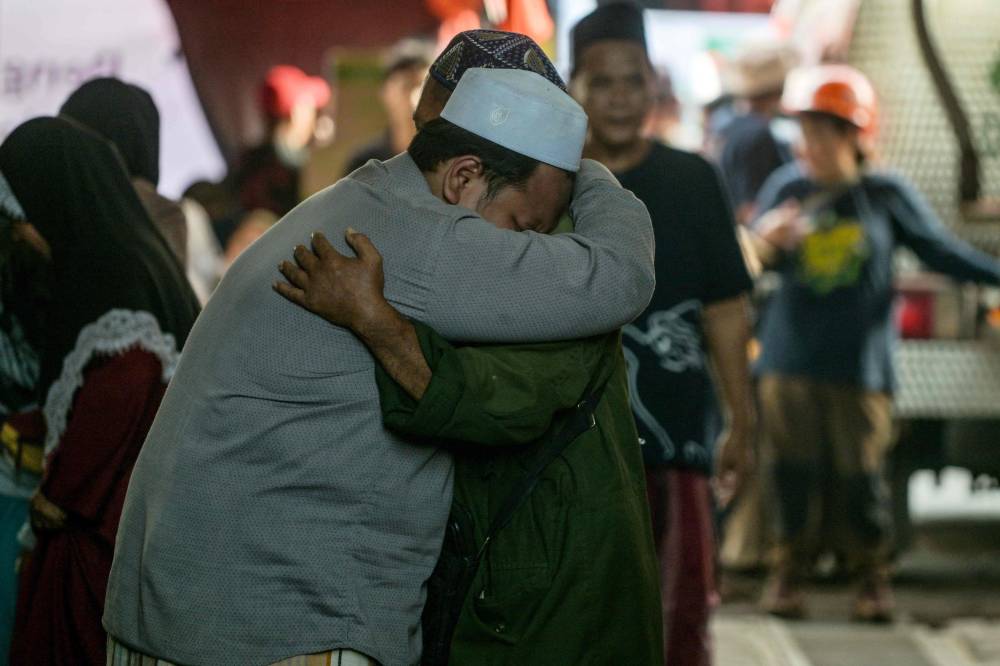 Relatives of missing students mourn as search and rescue operations continue at the Al Khoziny Islamic boarding school in Sidoarjo. Photo by Juni Kriswanto/AFP
