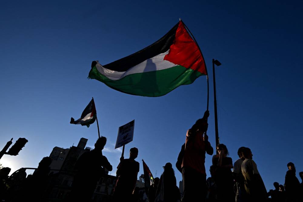 Pro-Palestinian demonstrators wave Palestinian flags and hold banners during a protest against the Israeli army's interception of the Global Sumud Flotilla in Buenos Aires. Photo by Luis Robayo/AFP